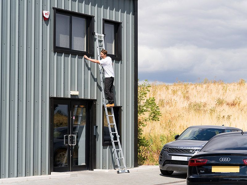 Worker using a ladder for safe access at height