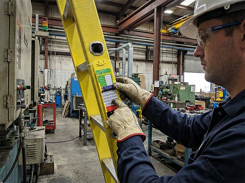 Worker recording a ladder inspection