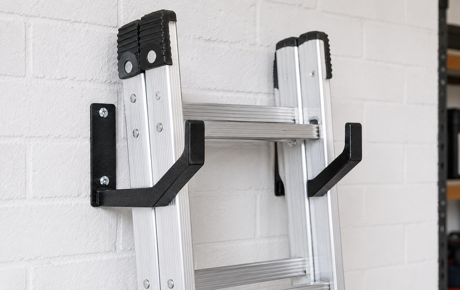 Ladder stored horizontally on wall-mounted hooks