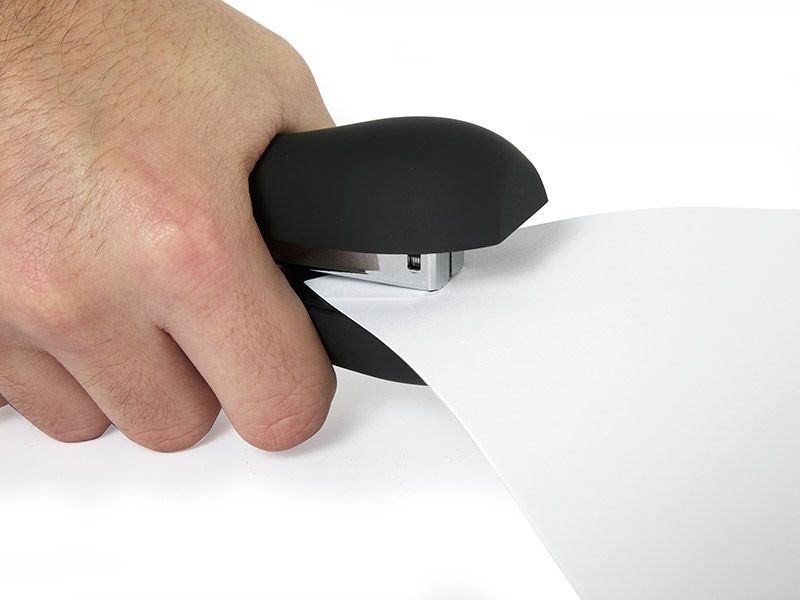 Hand using a stapler on paper