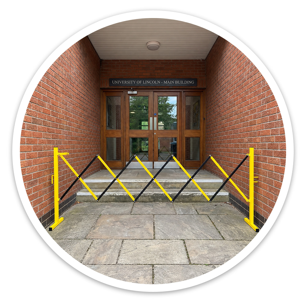 Small Expanding Safety Barrier opened to fit across the entrance steps of a brick university building