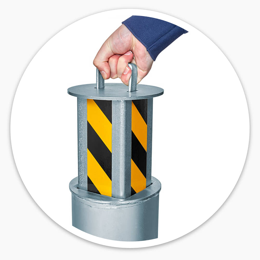 Hand lifting the yellow and black manual rising security post out of its in-ground base by the pull handle