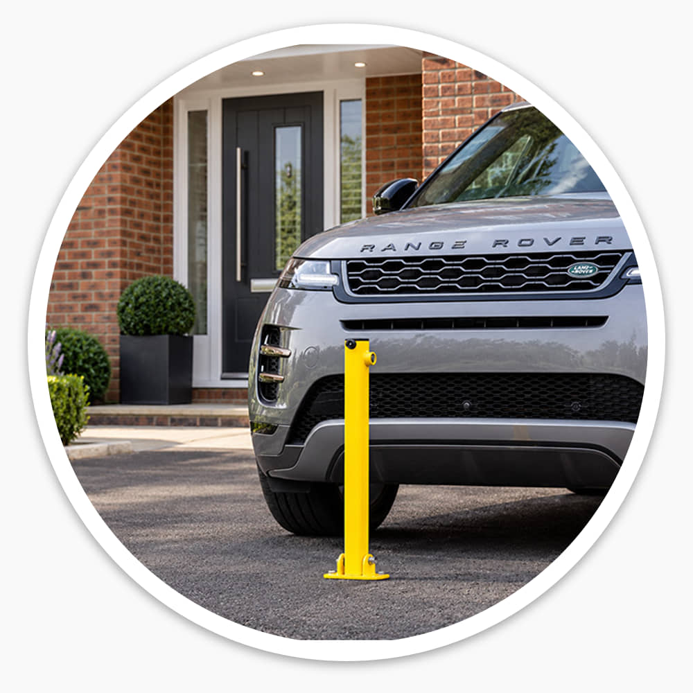 Yellow folding parking post raised in front of a grey Range Rover on a private house driveway