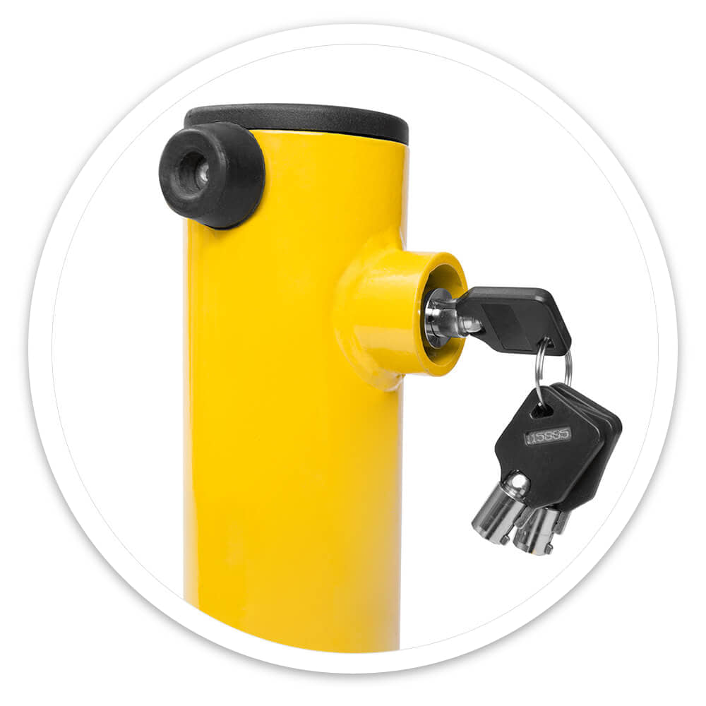 Close-up of the key lock on a yellow folding parking post with two keys hanging from it