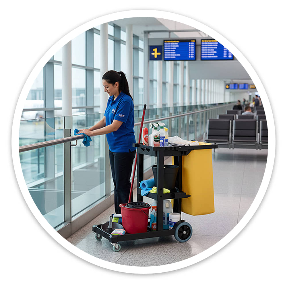 Economy Cleaning Cart on its castors and rubber tyres on a polished airport floor while a cleaner wipes a rail