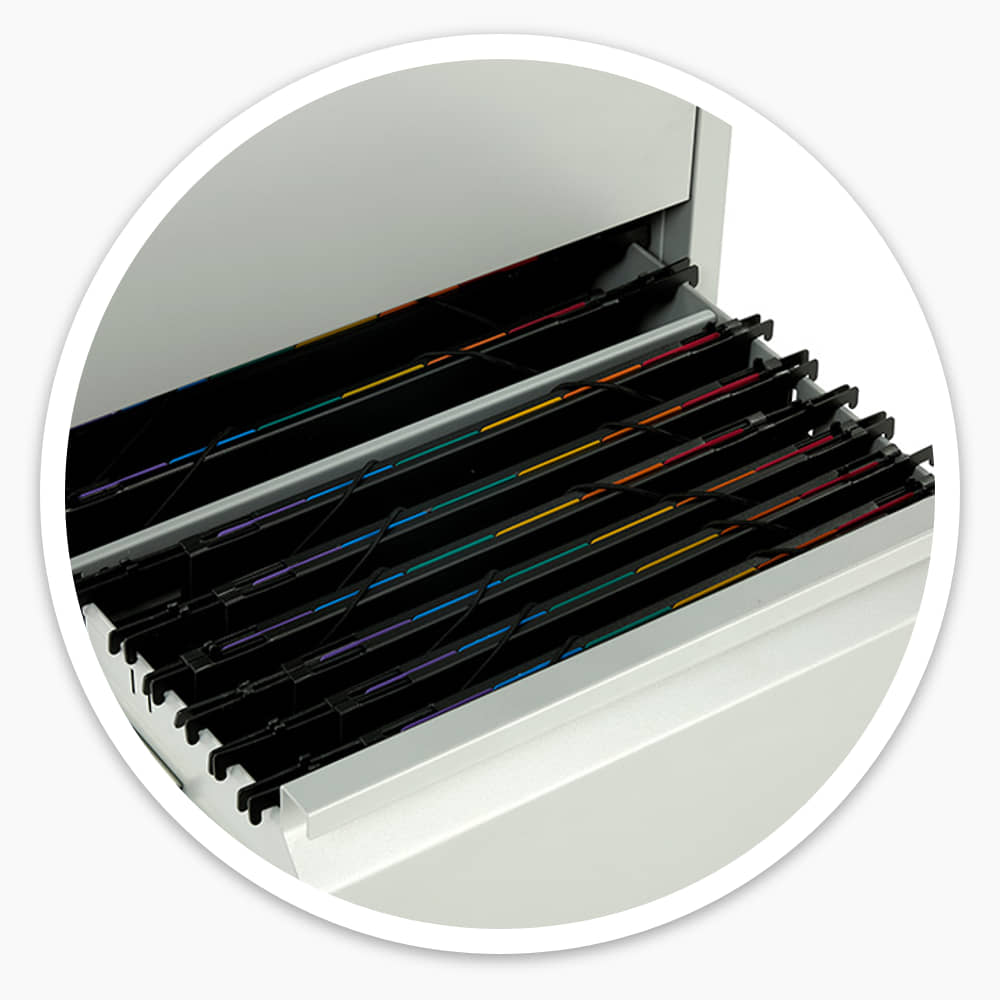 Open filing cabinet drawer with colour-coded suspension files hanging on the adjustable rails