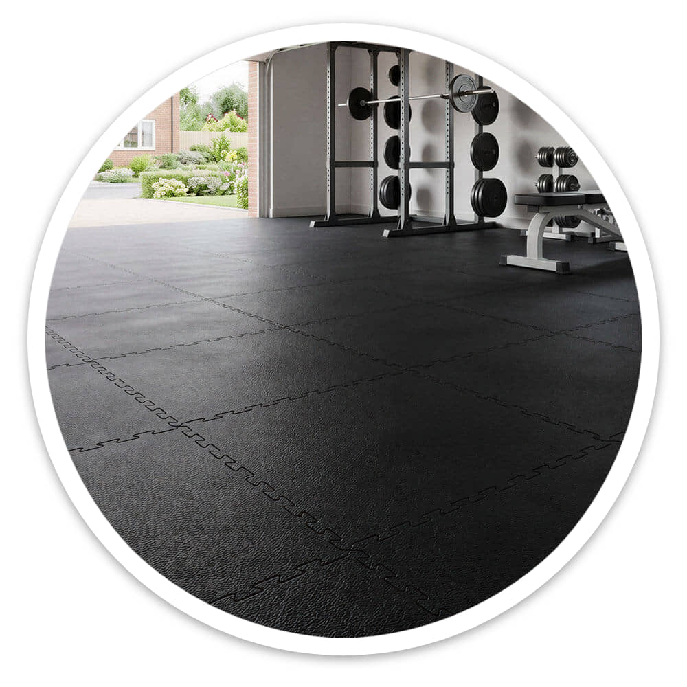 Garage with its door open, floored with black Fine Grain Interlocking Gym Floor Tiles and gym equipment at the back