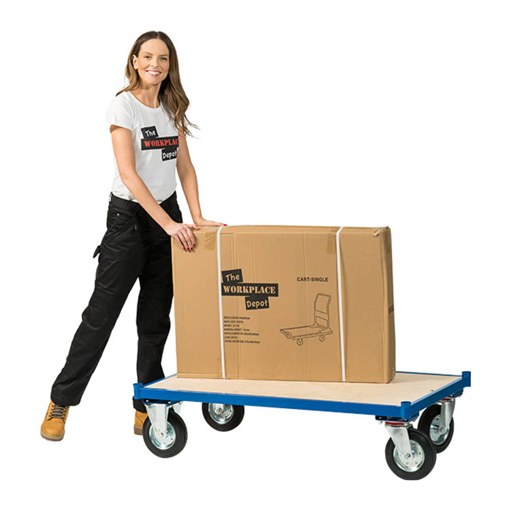 Woman in work clothes resting a large boxed load on the blue Platform Dolly Cart, on a white background