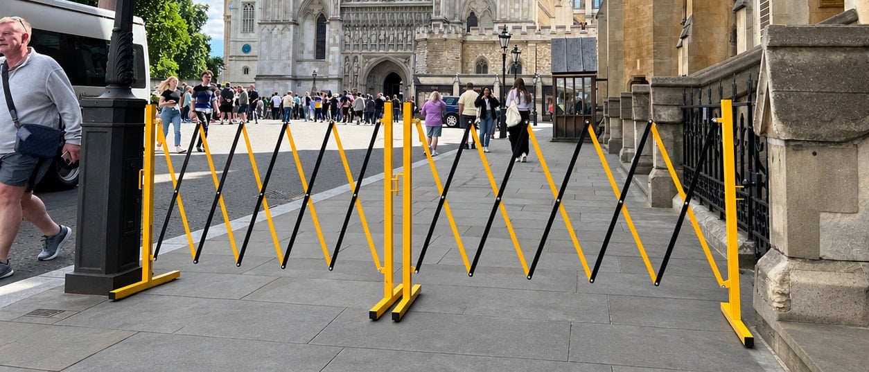 Two Small Expanding Safety Barriers linked end to end across a pavement near Westminster Abbey