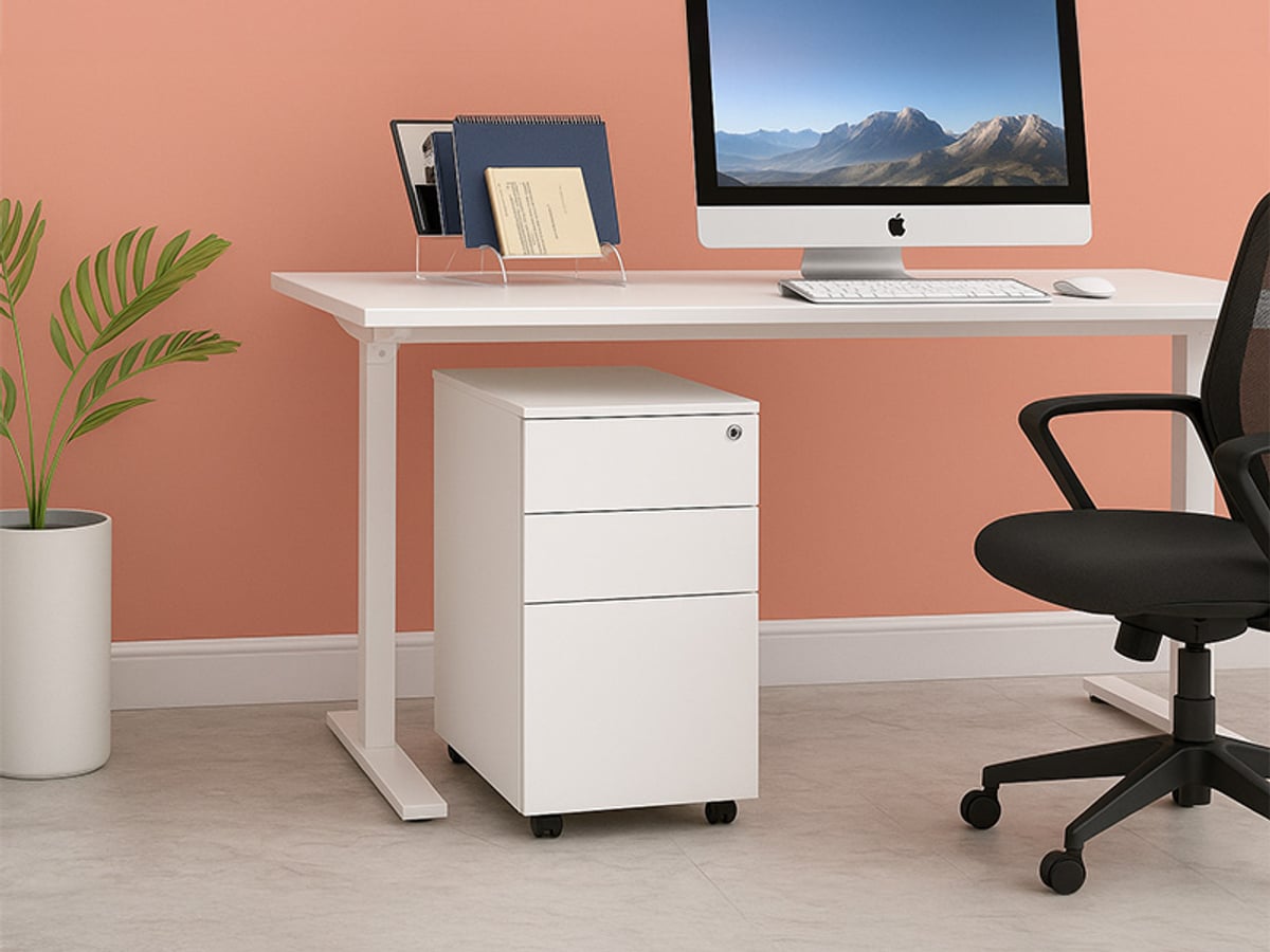 White 3 drawer mobile steel pedestal under a white desk in a peach-walled office with a black chair