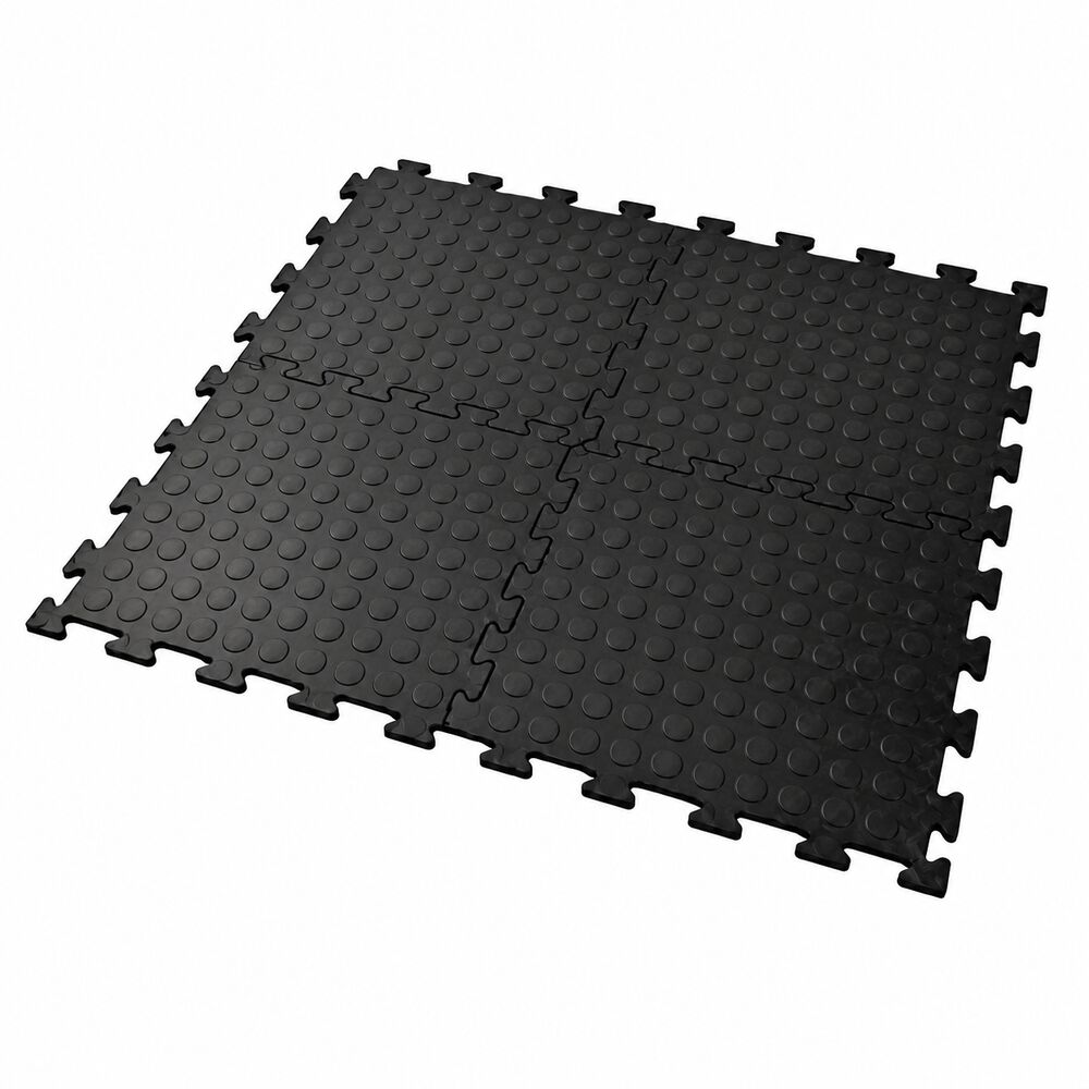 Black interlocking vinyl floor tiles with raised dotted surface