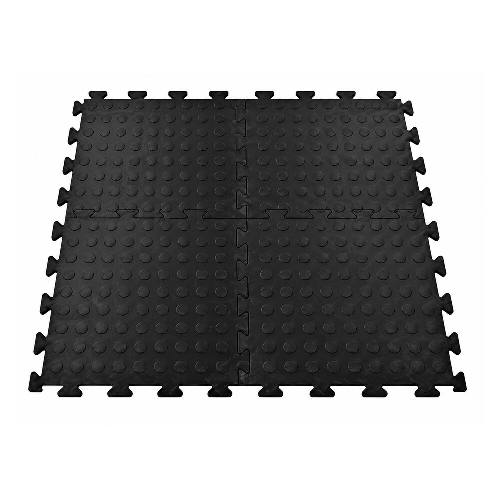 Black interlocking vinyl floor tiles with raised dotted surface