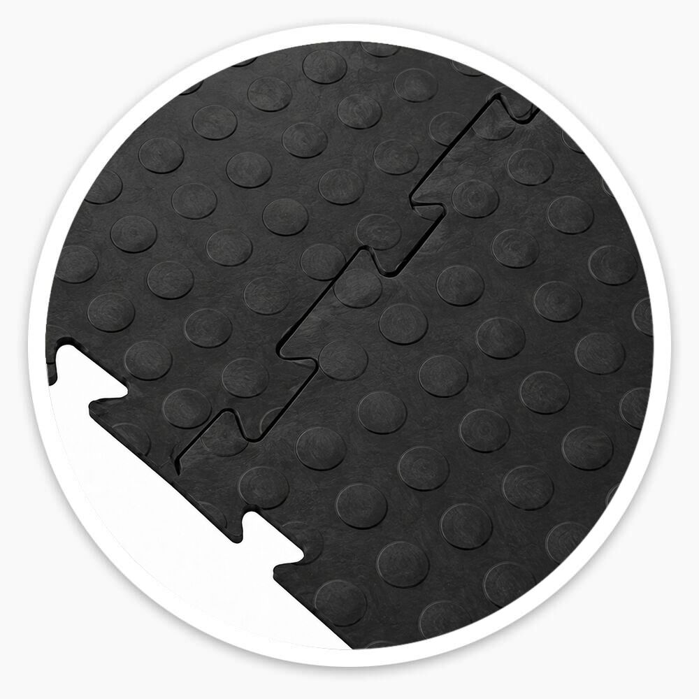 Black interlocking vinyl floor tiles with raised dotted surface